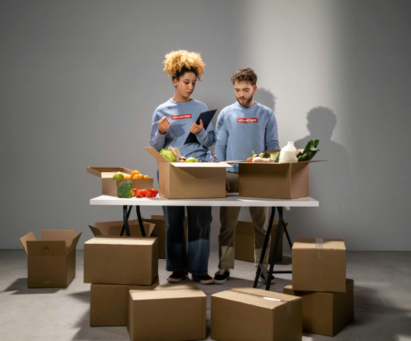 Man and Woman Standing near Brown Cardboard Boxes