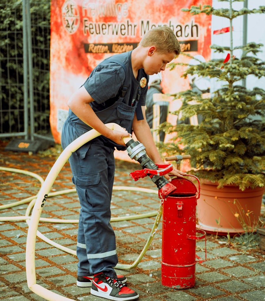 Boy with Hose at Firefighting Event