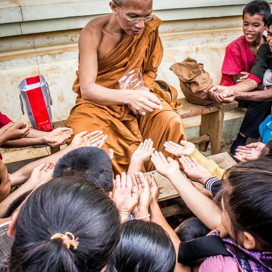 Monk Handing Towards Kids