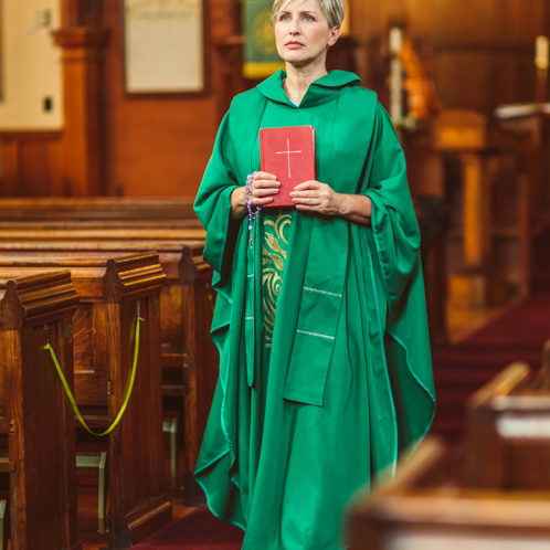 Woman in Green Cassock Walking on Aisle
